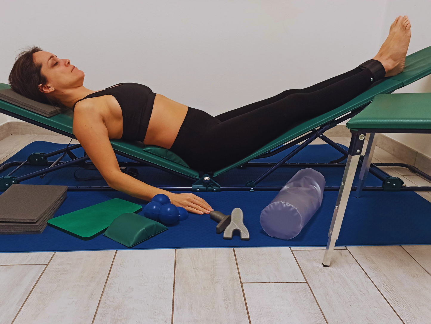 Tecnica di riequilibrio posturale con postura decompensata su panca. L'operatore guida la persona nell'allineamento corporeo con conseguente riduzione di tensione muscolare.