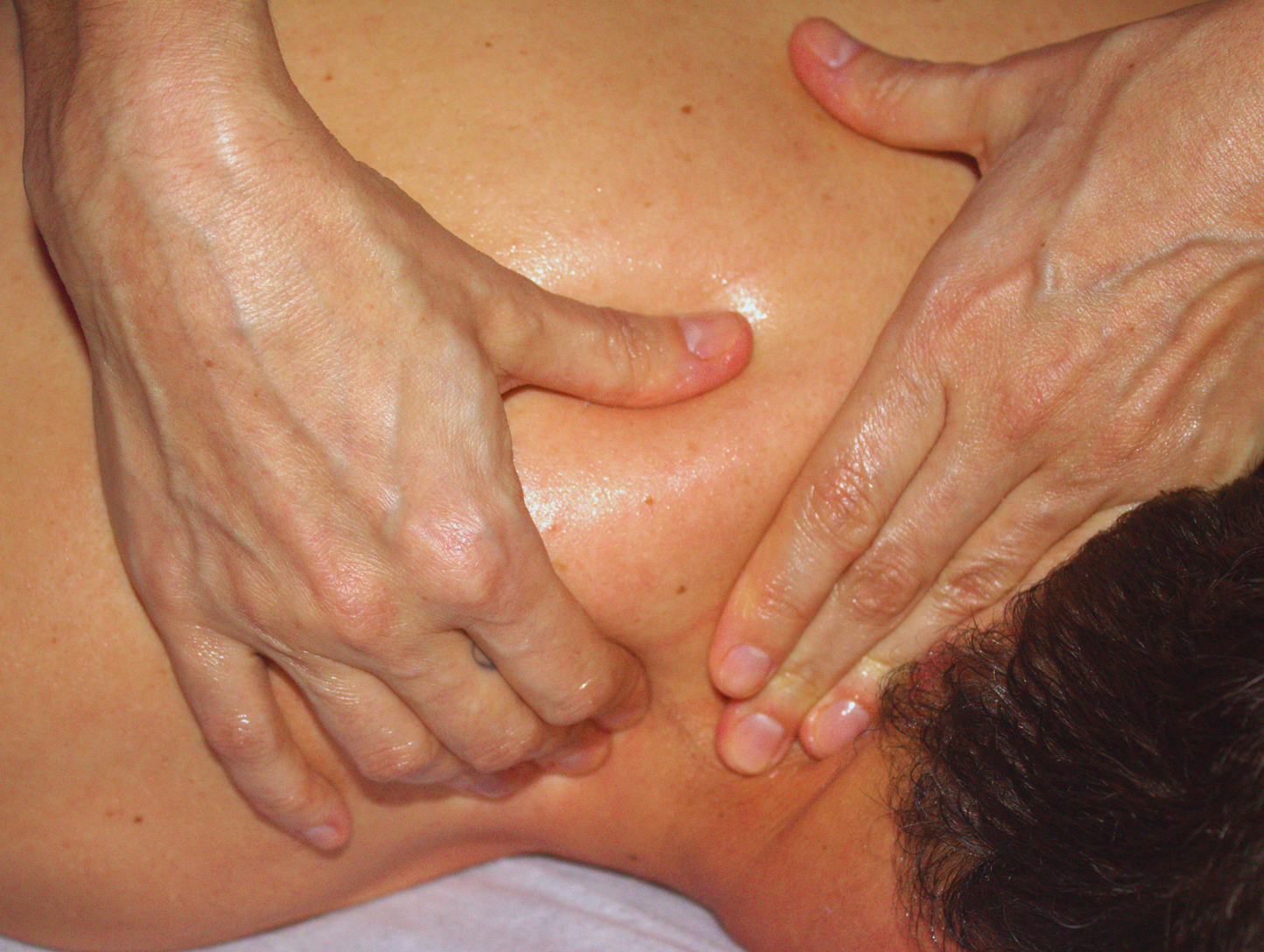 Mani esperte esequono un massaggio rilassante sulla spalla per sciogliere tensioni muscolari e favorire il benessere.
