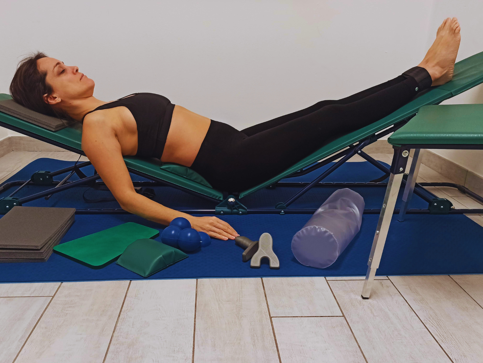 Tecnica di riequilibrio posturale con postura decompensata su panca. L'operatore guida la persona nell'allineamento corporeo con conseguente riduzione di tensione muscolare.