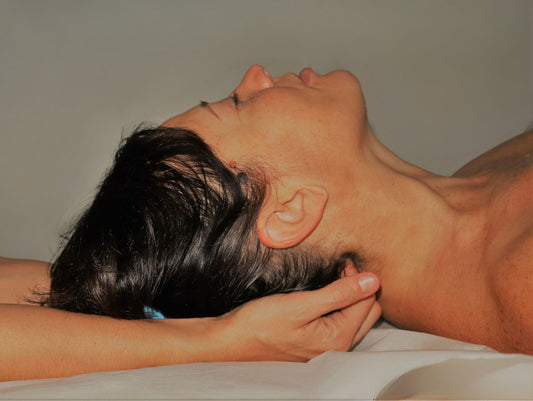 Tecnica di rilascio delle tensioni cervicali con il metodo craniosacrale. Mani esperte applica leggera pressione tra le vertebre per favorire il riequilibrio e il benessere.